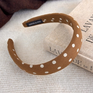 Détail du serre-tête rembourré marron à pois avec étiquette textile faite à la main