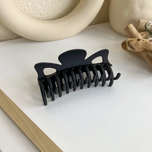 Gros plan sur une grande pince à cheveux noire mate avec une finition givrée raffinée