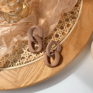 Close-up of vintage brown resin chain earrings on a rustic aesthetic background