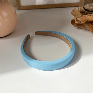 Macro detail of a light blue padded headband showing premium fabric texture and anti-slip lining