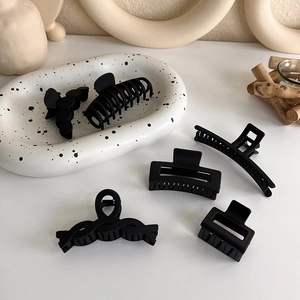 Lot détaillé de six pinces à cheveux noir mat aux formes géométriques variées