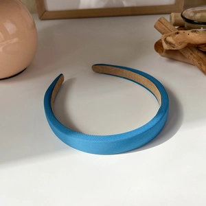 Detail of blue padded headband showing fine fabric texture and brown non-slip lining