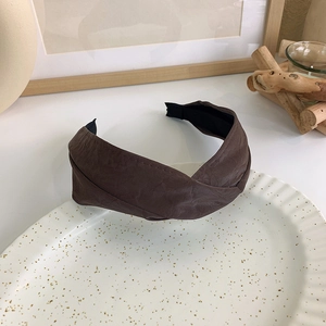 Nahaufnahme des dunkelbraunen Stirnbands mit gekreuztem Kunstleder und Textur