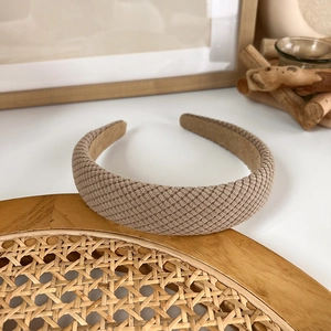 Detail of wide padded headband with textured checkerboard weave and soft inner lining