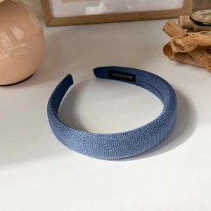 Detailed macro view of blue knitted sponge headband with hand made woven label detail