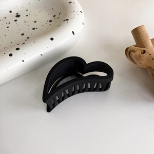 Détail de la pince à cheveux cœur évidé noir mat montrant la finition texturée