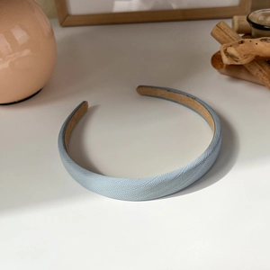 Macro detail of sky blue headband showing high-quality herringbone fabric texture