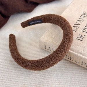 Détail du serre-tête éponge marron café avec une étiquette textile faite main à l'intérieur