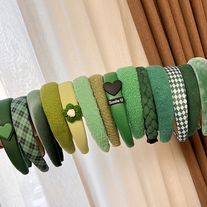 Detailed macro view of various green knit and fabric headbands with diverse textures