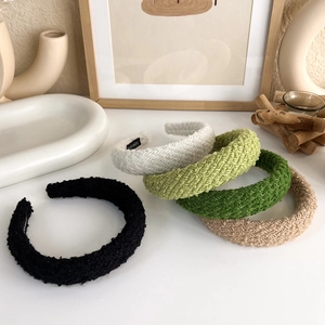 Detailed macro view of five colorful knit thick headbands with handmade inner labels