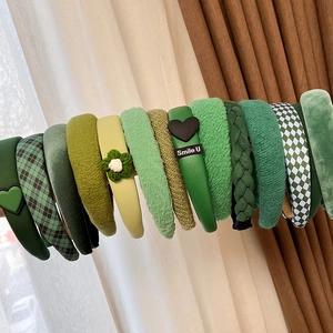 Detailed close-up of vintage green headbands in velvet, knit, and checkered textures