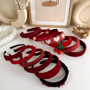 Gros plan de serre-têtes assortis en velours rouge et tricot avec détails cœur et cerise