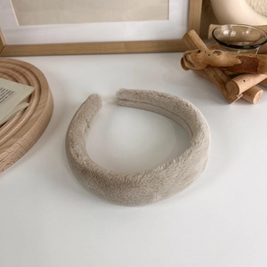 Gros plan du serre-tête beige en peluche épaisse avec texture en fausse fourrure douce