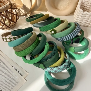 Variety of green fabric headbands featuring knit, checkered and plush textures for women
