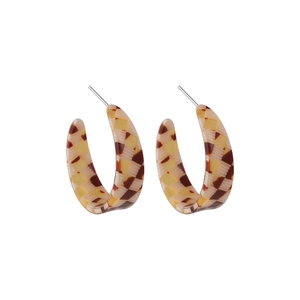 Detailed view of C-shaped resin earrings featuring a vintage tortoiseshell checkered pattern