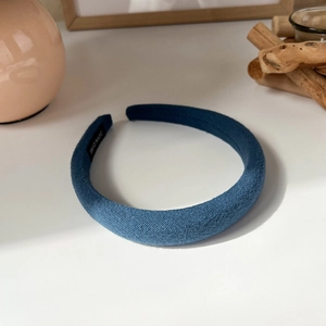 Detail of blue padded sponge headband featuring a woven handmade label on the inner side