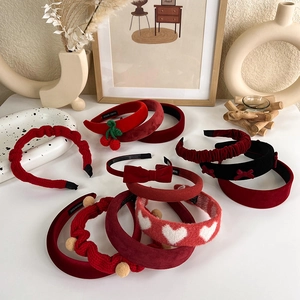 Détail de serre-têtes en velours rouge avec décorations de cerises et nœuds faits main