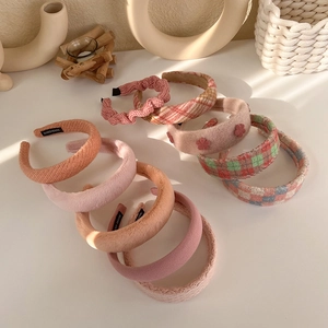 Detail of assorted handmade plush sponge headbands in soft pink and floral textures