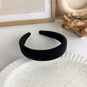 Detail view of a thick black padded headband on a decorative ceramic plate