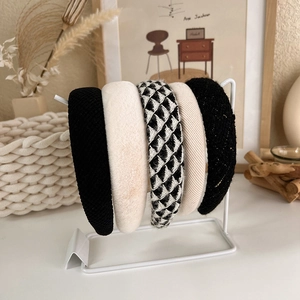 Detailed close-up of five stylish textured headbands in plaid and solid neutral tones