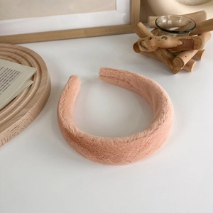 Détail d'un serre-tête en peluche rose épais avec texture douce en fausse fourrure