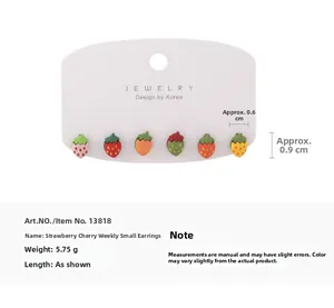 Close-up of colorful resin strawberry stud earrings set on a white jewelry display card