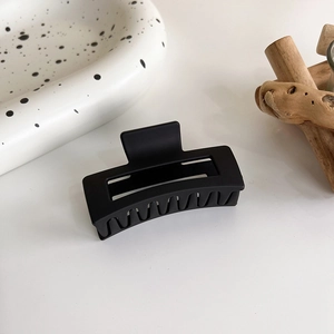 Détail de la pince à cheveux rectangulaire noire mate avec une forte adhérence