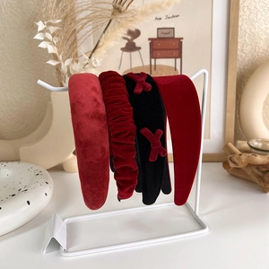 Ensemble détaillé de serre-têtes en velours rouge et noir sur un support d'affichage