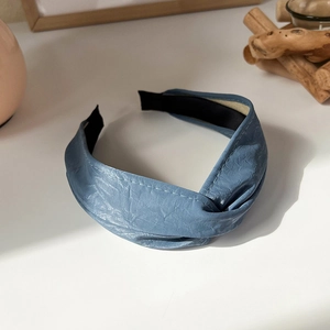 Detail of blue knot headband with faux leather texture and soft black lining padding