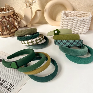 Detail showing various green headbands in velvet, knit, and plaid textures with vintage style