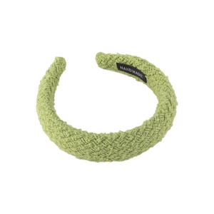Light green woven headband with high top design and handmade label on white background