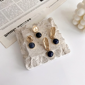 Klein blue stone earrings with vintage hammered gold texture on a decorative tray
