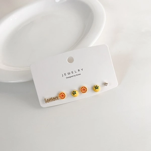 6-piece set of sweet yellow lemon stud earrings on a white display card with ceramic plate