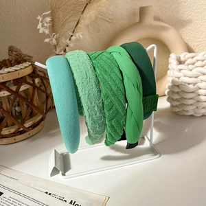 Detail of five-piece green headband set in assorted knit and pleated fabric textures
