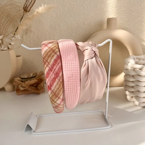 Detailed set of three pink textured headbands on a stylish display stand for women