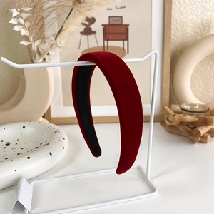 Détail d'un bandeau large en velours rouge foncé sur un support dans un décor chaleureux