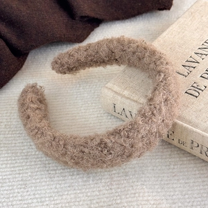 Gros plan du serre-tête épais en polaire pelucheuse camel montrant la texture douce