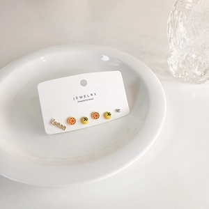 Detailed view of a six-piece fruit-themed lemon earring set on a white jewelry card