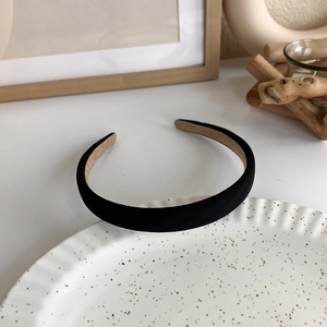 Detailed texture of a black fabric headband on a ceramic plate with ins style background