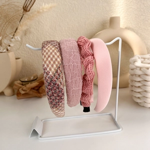 Detailed close-up of pink and yellow textured fabric headbands on a minimalist display
