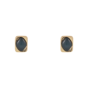 Detailed view of vintage gold stud earrings featuring a minimalist dark green diamond inlay