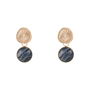 Detail of hammered gold metal studs with dark grey marble resin drops on white background