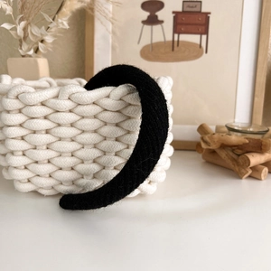 Close-up of black fuzzy knitted wide headband with soft texture and warm winter material