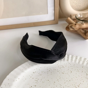 Detailed view of the black twisted faux leather headband with premium textured finish