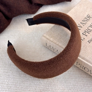 Détail d'un serre-tête rembourré en peluche marron foncé sur un livre vintage d'automne