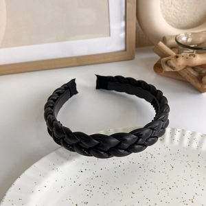 Detail of black braided leather headband with non-slip teeth for elegant hair styling