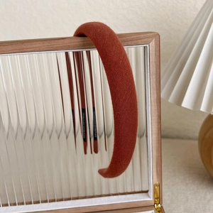 Detailed view of red knitted headband hanging on a wooden textured glass frame