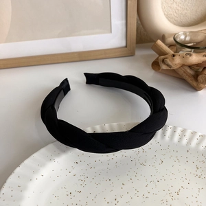 Close-up of black twisted knit headband with elegant woven fabric texture for women