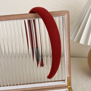 Detail of red knitted headband hanging on a mirror with soft vintage lighting