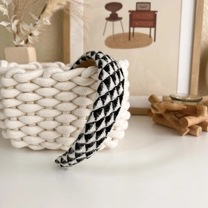 Detailed view of black and white checkered thick headband with soft knitted texture